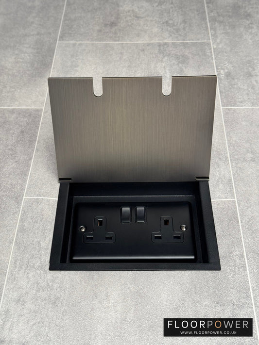 Antique brass recessed floor socket with a double 13amp switched plug socket, in a tiled floor.