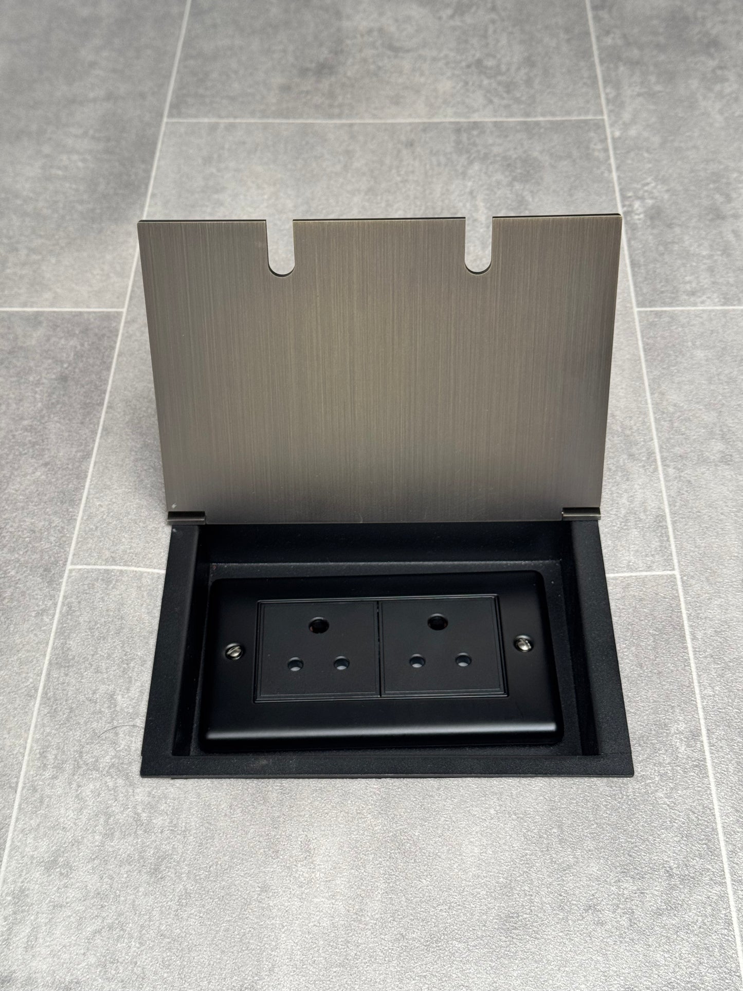Double 5 amp recessed floor socket for lighting with antique brass lid set into the floor.