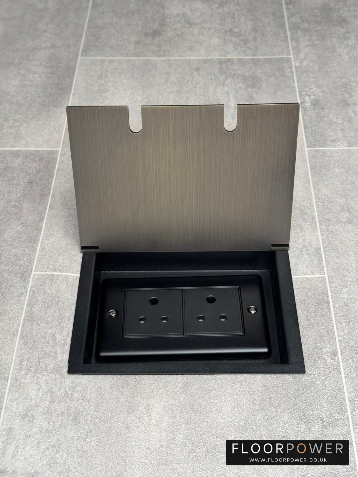 Double 5 amp recessed floor socket for lighting with antique brass lid set into the floor.
