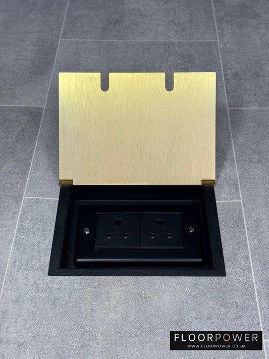 Double 5 amp recessed floor socket for lighting with satin brass lid set into the floor.