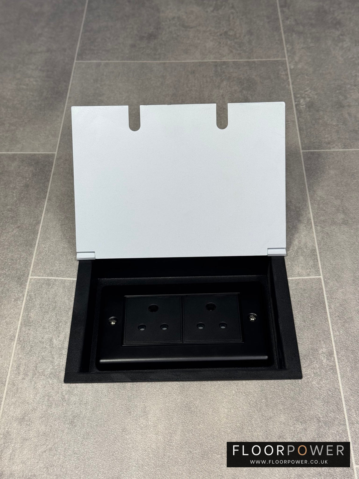 Double 5 amp recessed floor socket for lighting with white lid set into the floor.