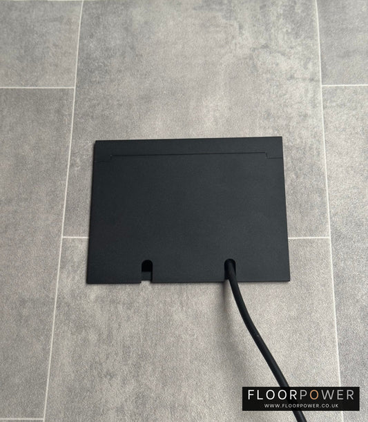Double Matt Black Recessed Floor Socket With Lid Closed Flat Showing Just Cable Coming Out If The Socket - Front On View