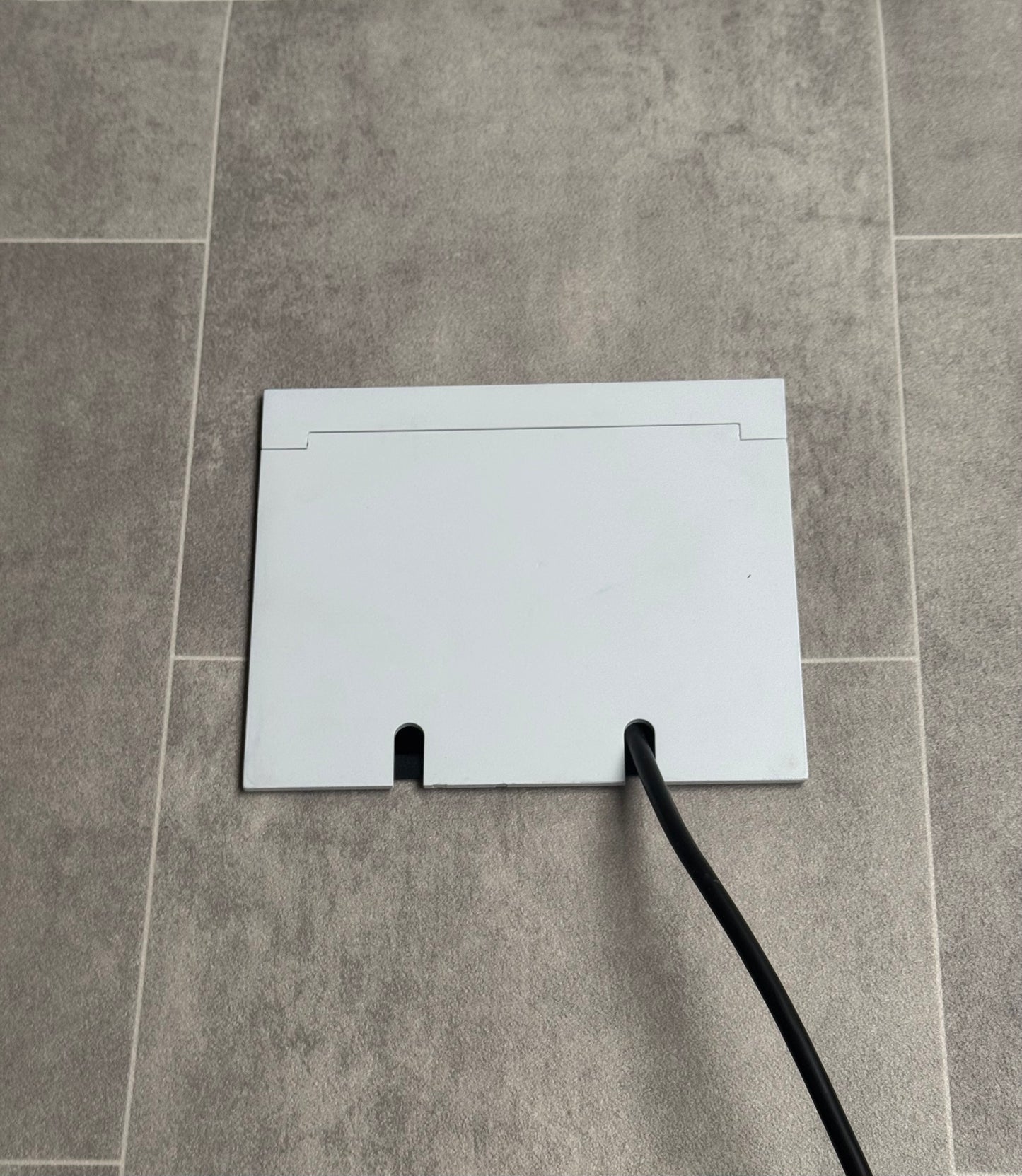 Double Matt White Recessed Floor Socket With Lid Closed Flat Showing Just Cable Coming Out If The Socket - Side On View.