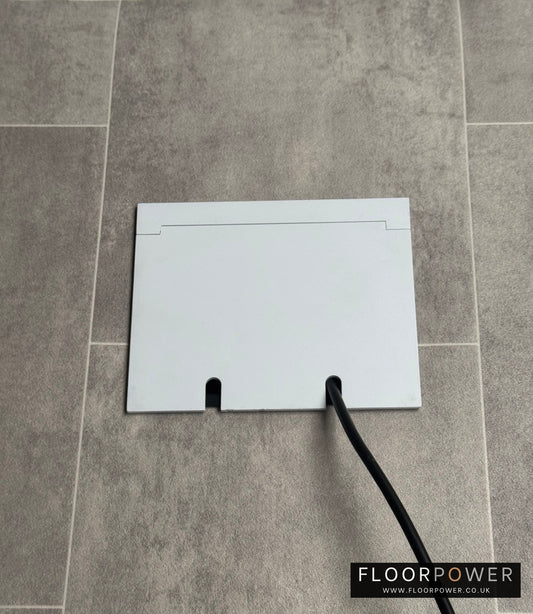 Double Matt White Recessed Floor Socket With Lid Closed Flat Showing Just Cable Coming Out If The Socket - Side On View.