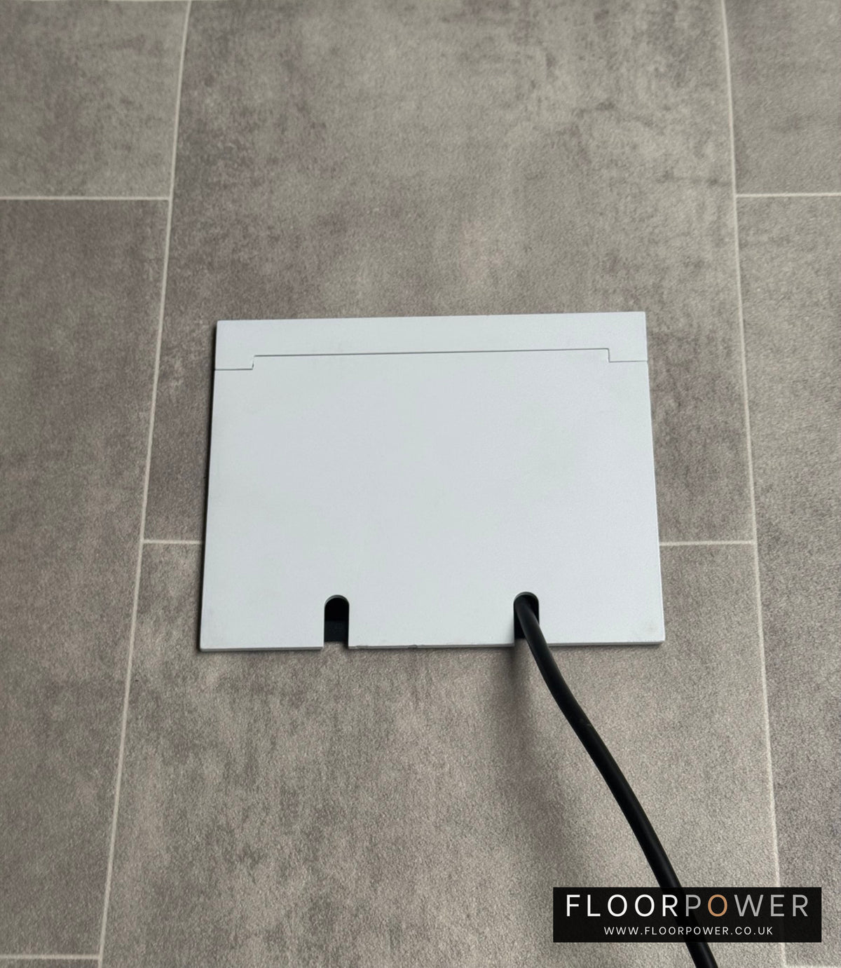 Double Matt White Recessed Floor Socket With Lid Closed Flat Showing Just Cable Coming Out If The Socket - Side On View.