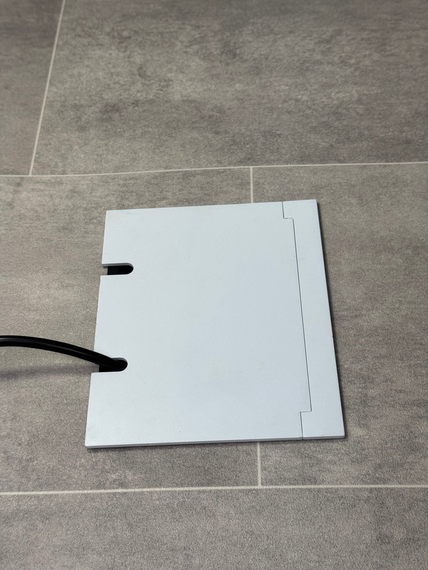 Double Matt White Recessed Floor Socket With Lid Closed Flat Showing Just Cable Coming Out If The Socket - Side On View.