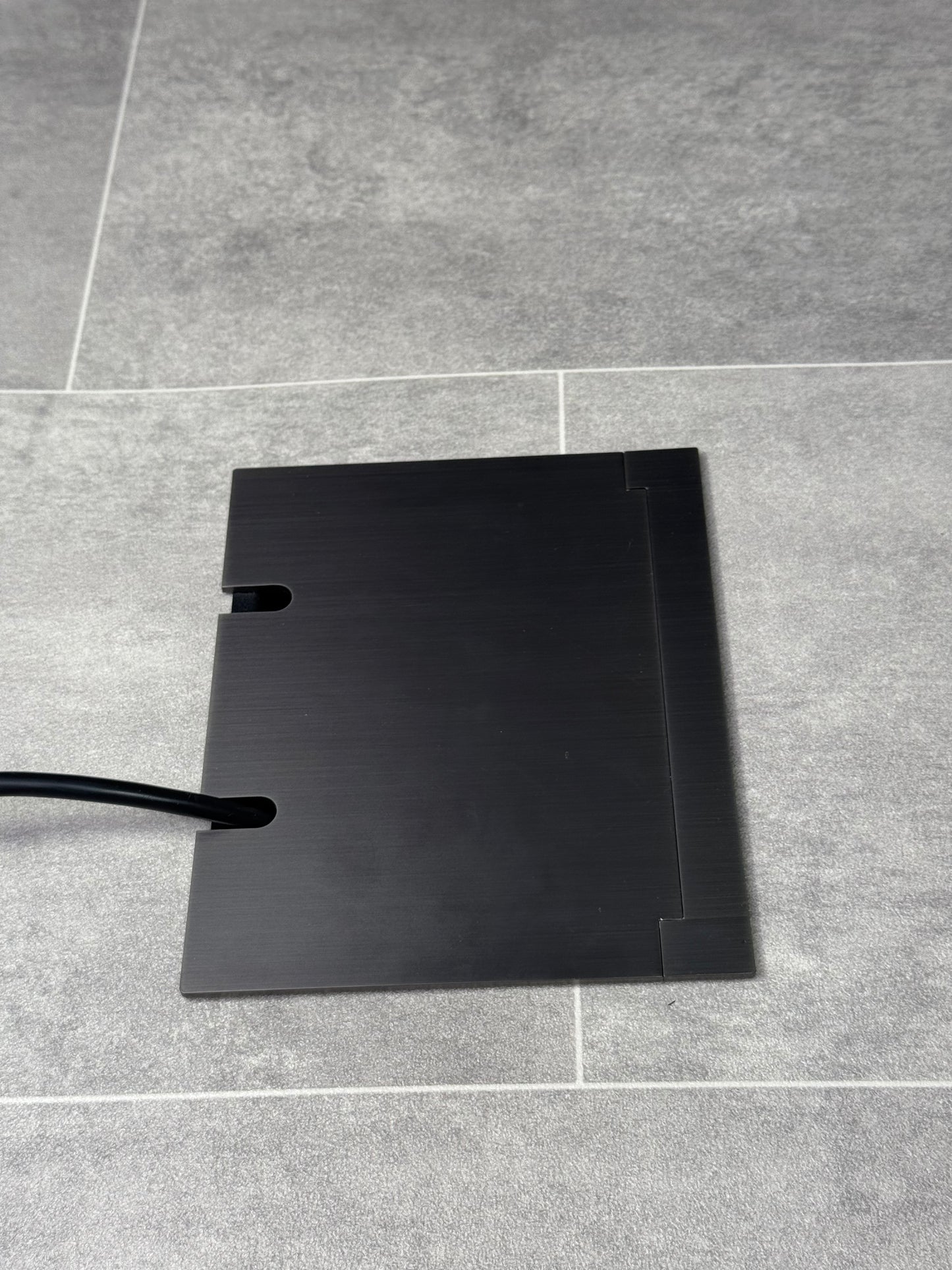 Double Old Bronze Recessed Floor Socket With Lid Closed Flat Showing Just Cable Coming Out If The Socket - Side On View.
