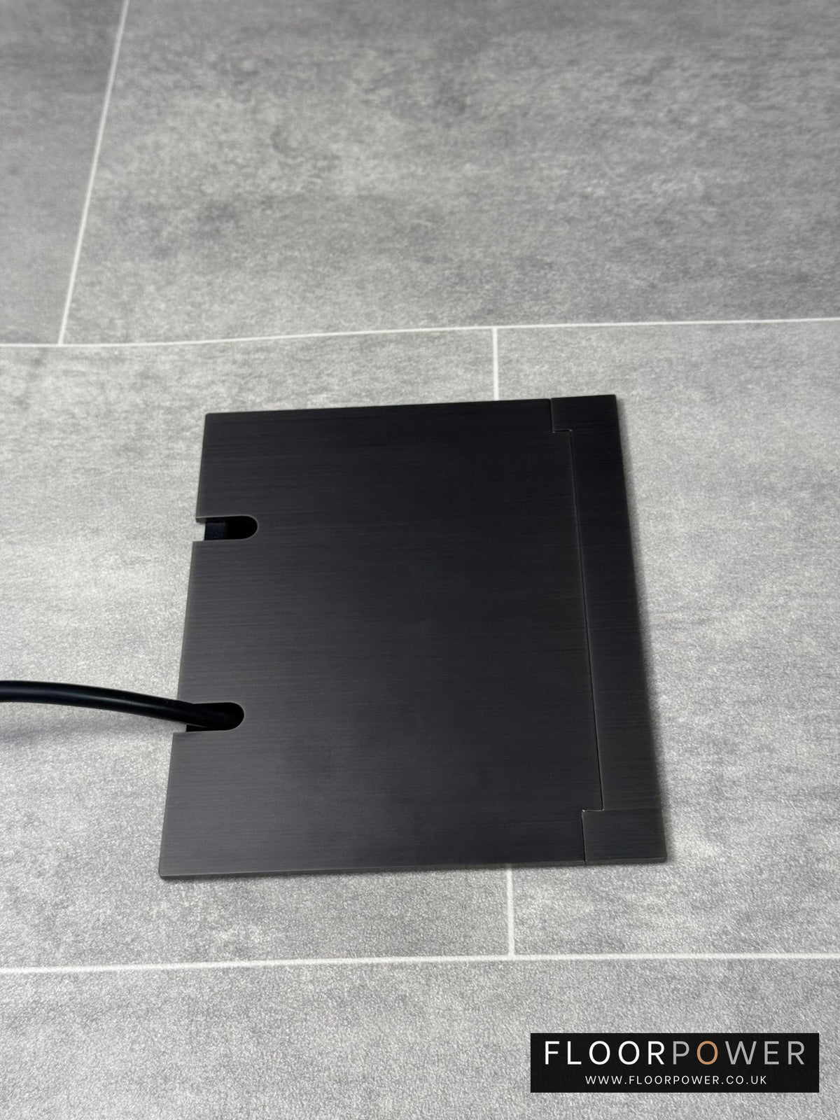 Double Old Bronze Recessed Floor Socket With Lid Closed Flat Showing Just Cable Coming Out If The Socket - Side On View.