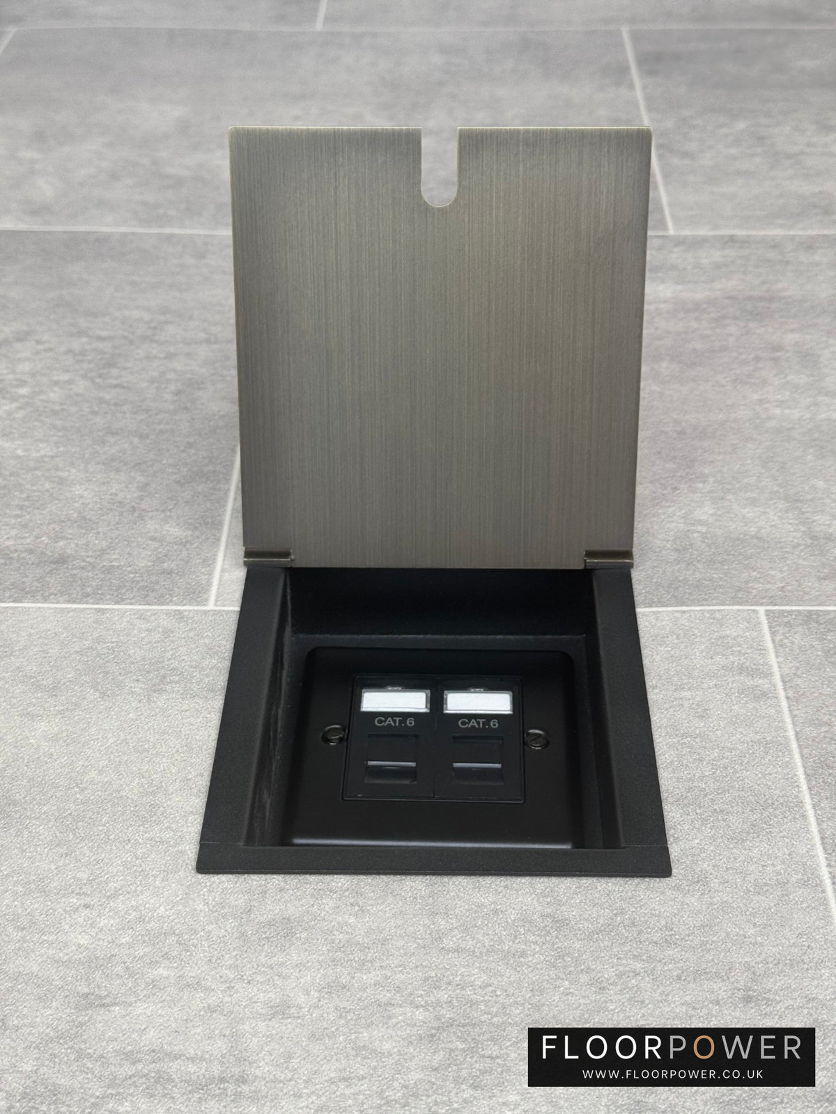 A recessed floor socket with an antique brass cover, two RJ45 sockets, designed for network cable management.