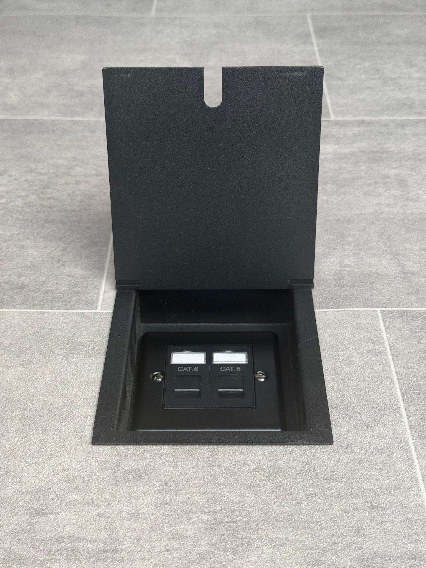 A matt black recessed floor socket showing a 2 gang Cat6 RJ45 Ethernet socket inside.