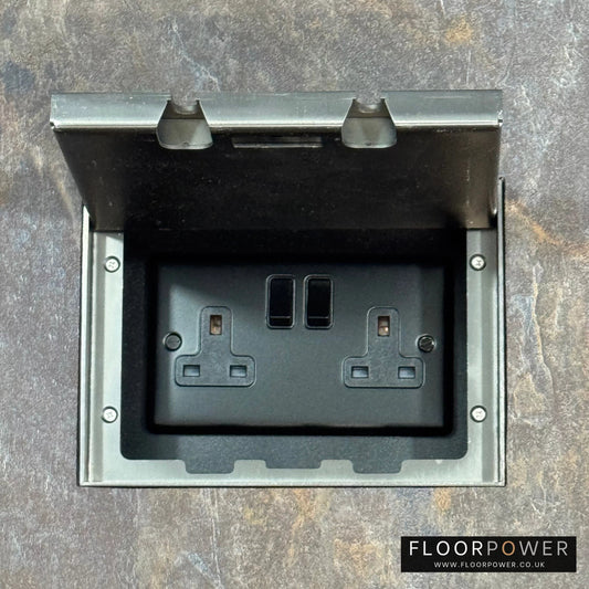 Old Bonze Double Recessed Flush Floor Socket with 13A Switched Plug Socket n a stone floor.