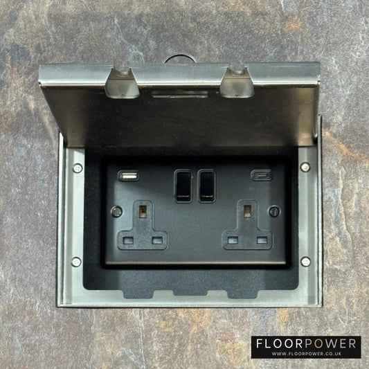 Old Bronze Double Recessed Flush Floor Socket with USB A + C Plug Socket n a stone floor.