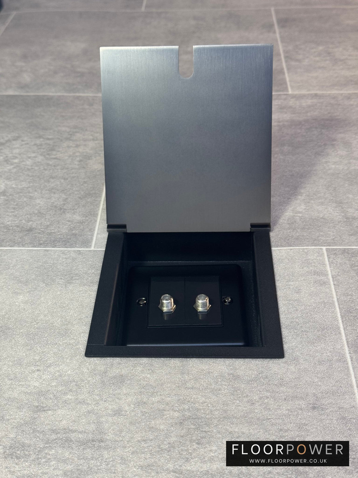 A single old bronze recessed floor socket with a 2 gang satellite socket.