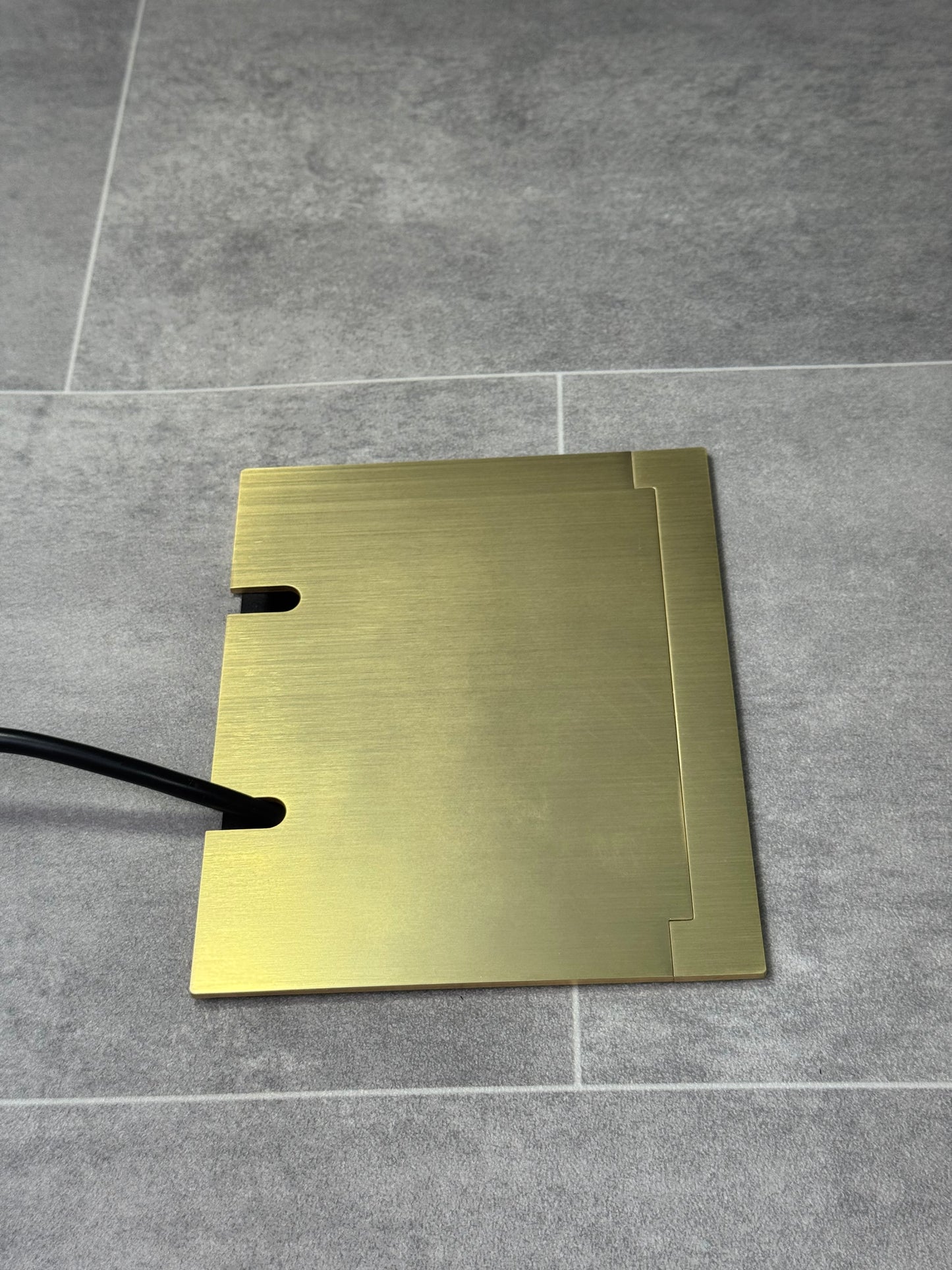 Double Satin Brass Recessed Floor Socket With Lid Closed Flat Showing Just Cable Coming Out If The Socket - Side On View.