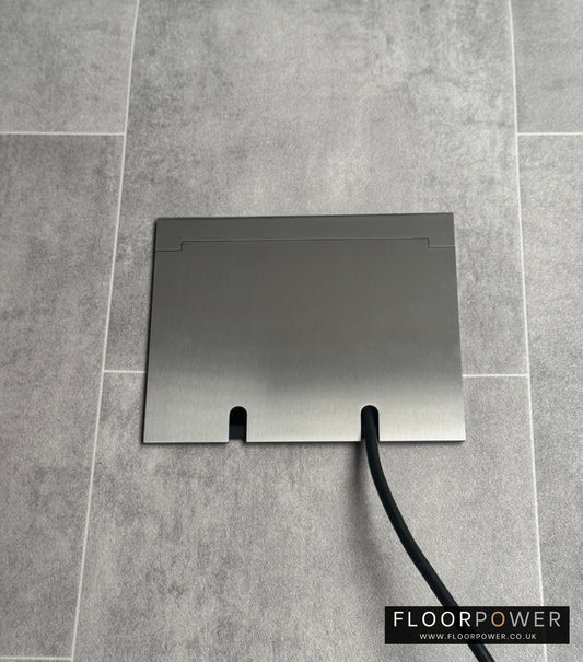 Double Satin Stainless Recessed Floor Socket With Lid Closed Flat Showing Just Cable Coming Out If The Socket - Front On View.