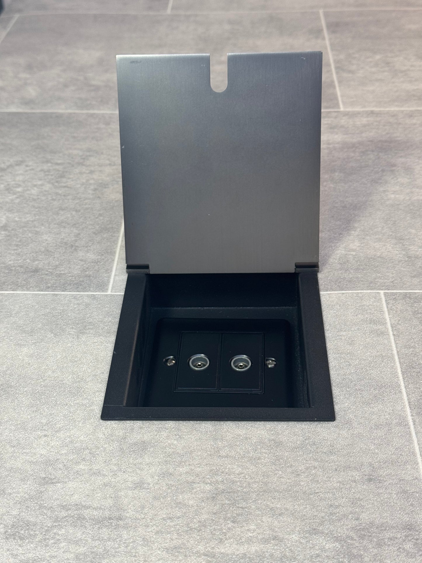 Old bronze recessed floor socket with a 2 gang TV socket, shown in an open position with the surrounding floor visible.