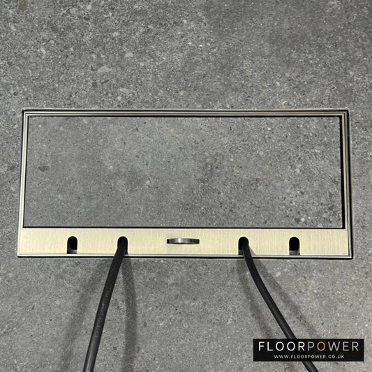 Flush Recessed Floor Socket with Antique Brass Surround in grey stone floor showing closed lid and 2 wires coming out