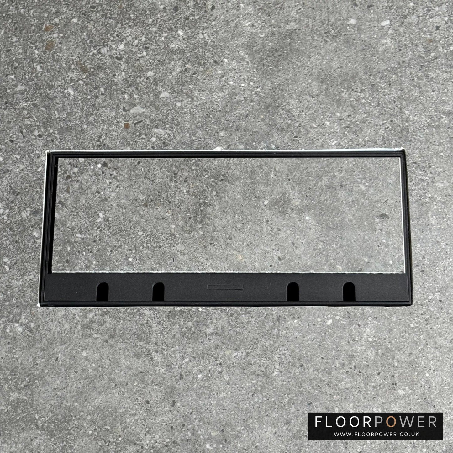 Flush Recessed Floor Socket with Black Surround in grey stone floor