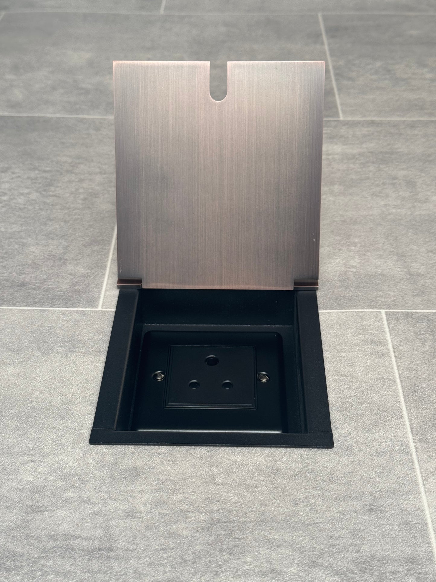 Antique copper recessed floor socket open showing a 5 amp round pin socket (for lighting).