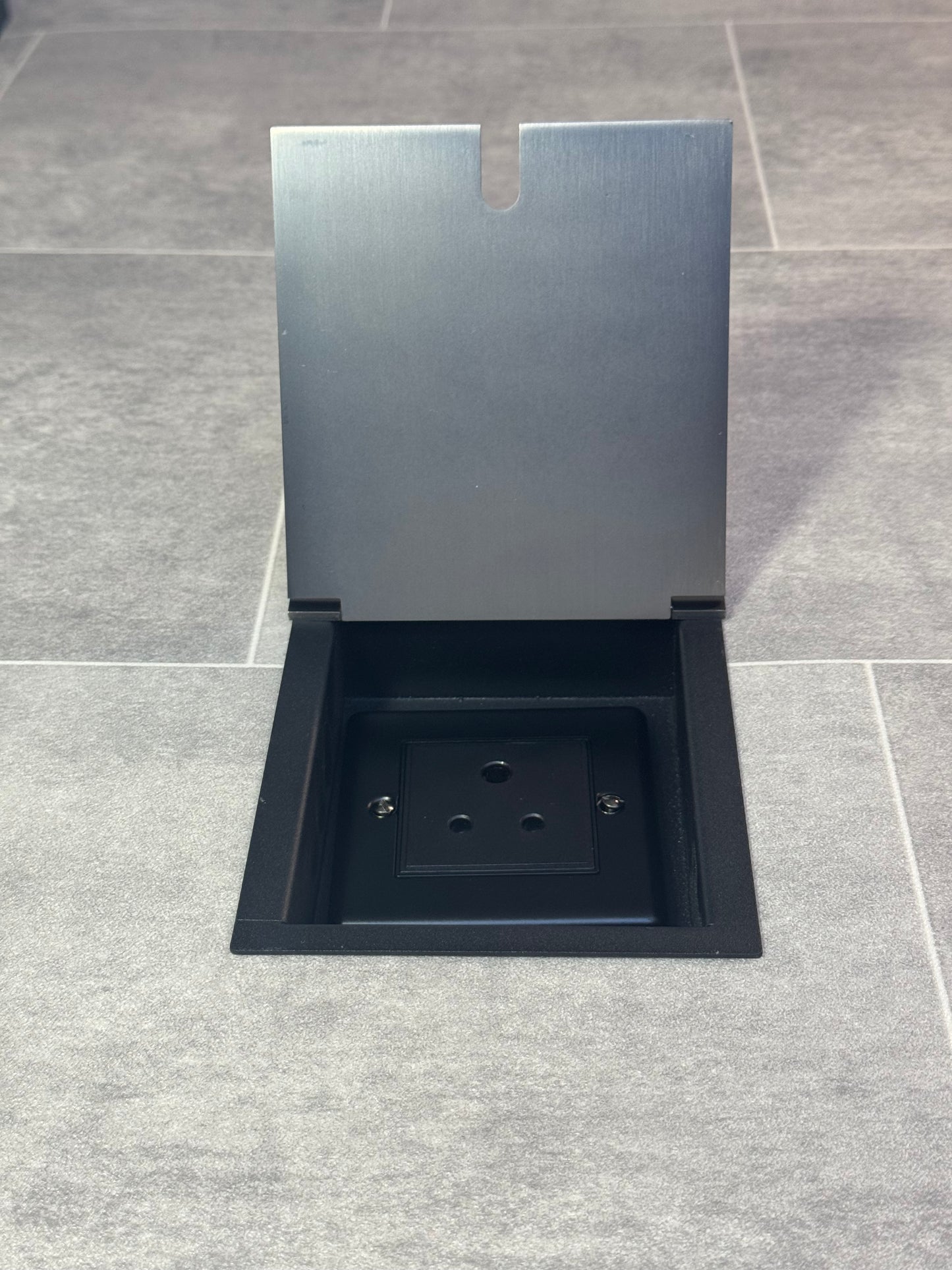 Recessed floor socket in old bronze with the cover open showing the single 5 Amp round pin socket for lighting.