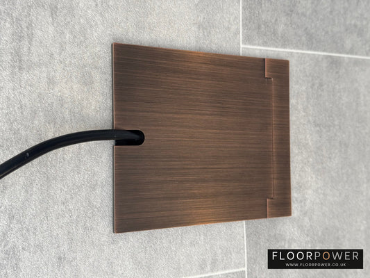 Single Antique Copper Recessed Floor Socket With Lid Closed Flat Showing Just Cable Coming Out If The Socket - Front On View.