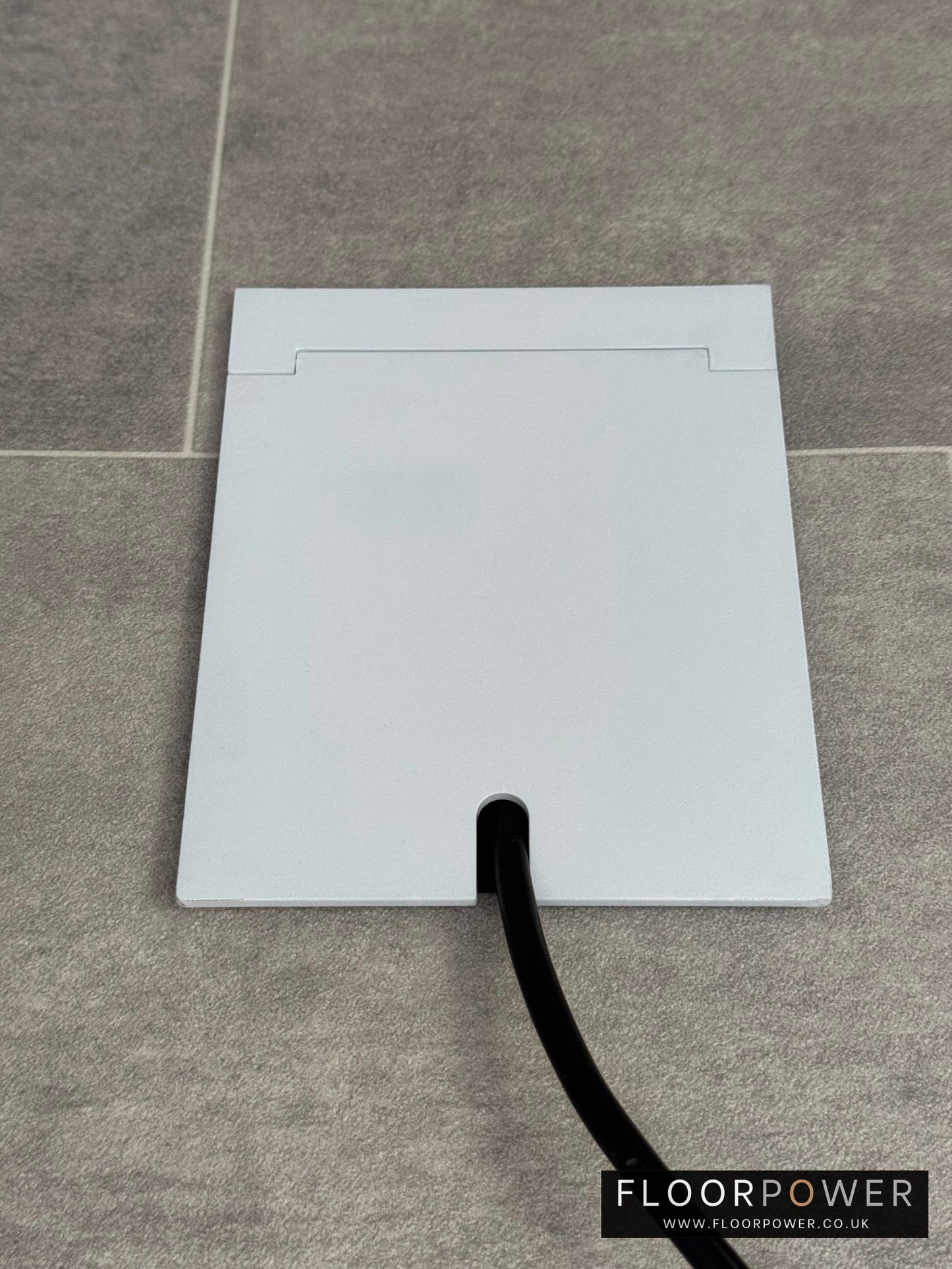 Single Matt White Recessed Floor Socket With Lid Closed Flat Showing Just Cable Coming Out If The Socket - Front On View.