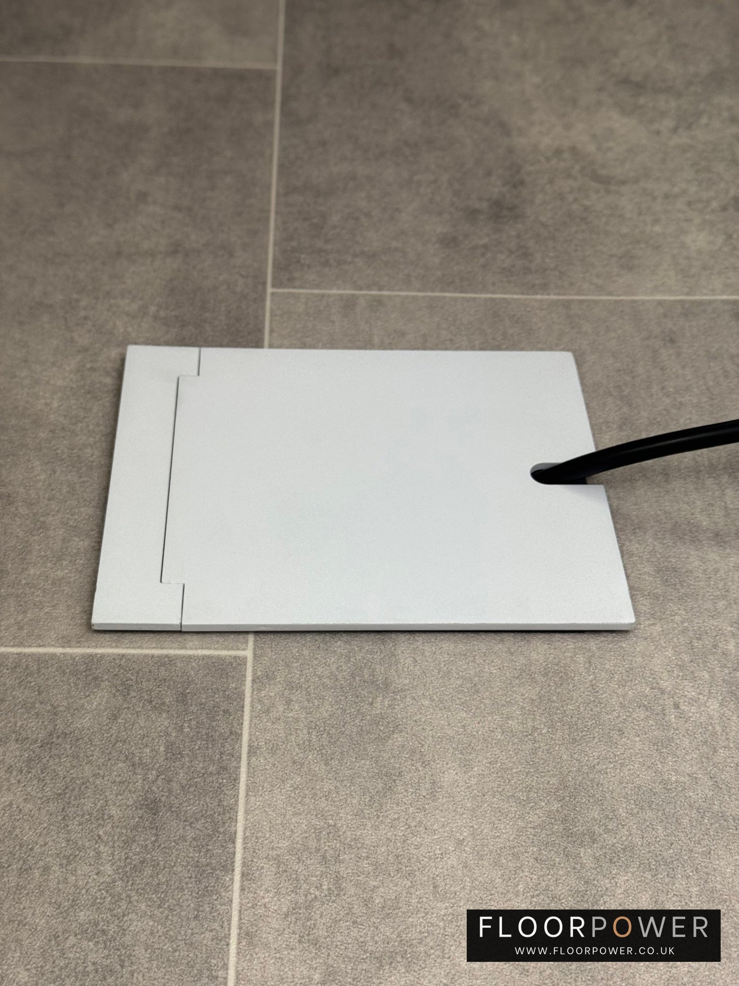 Single Matt White Recessed Floor Socket With Lid Closed Flat Showing Just Cable Coming Out If The Socket - Side On View.