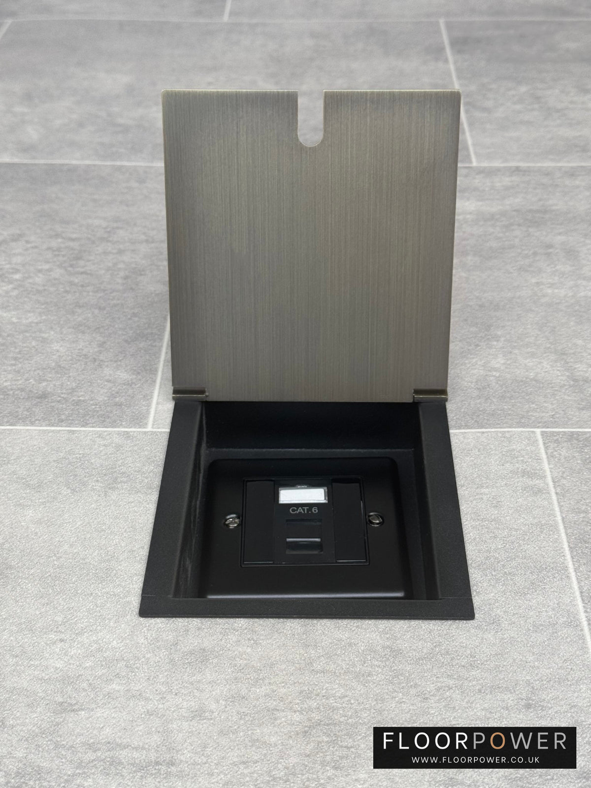 An antique brass finish recessed floor socket with a black base, opened to reveal the internal Cat6 RJ45 socket.