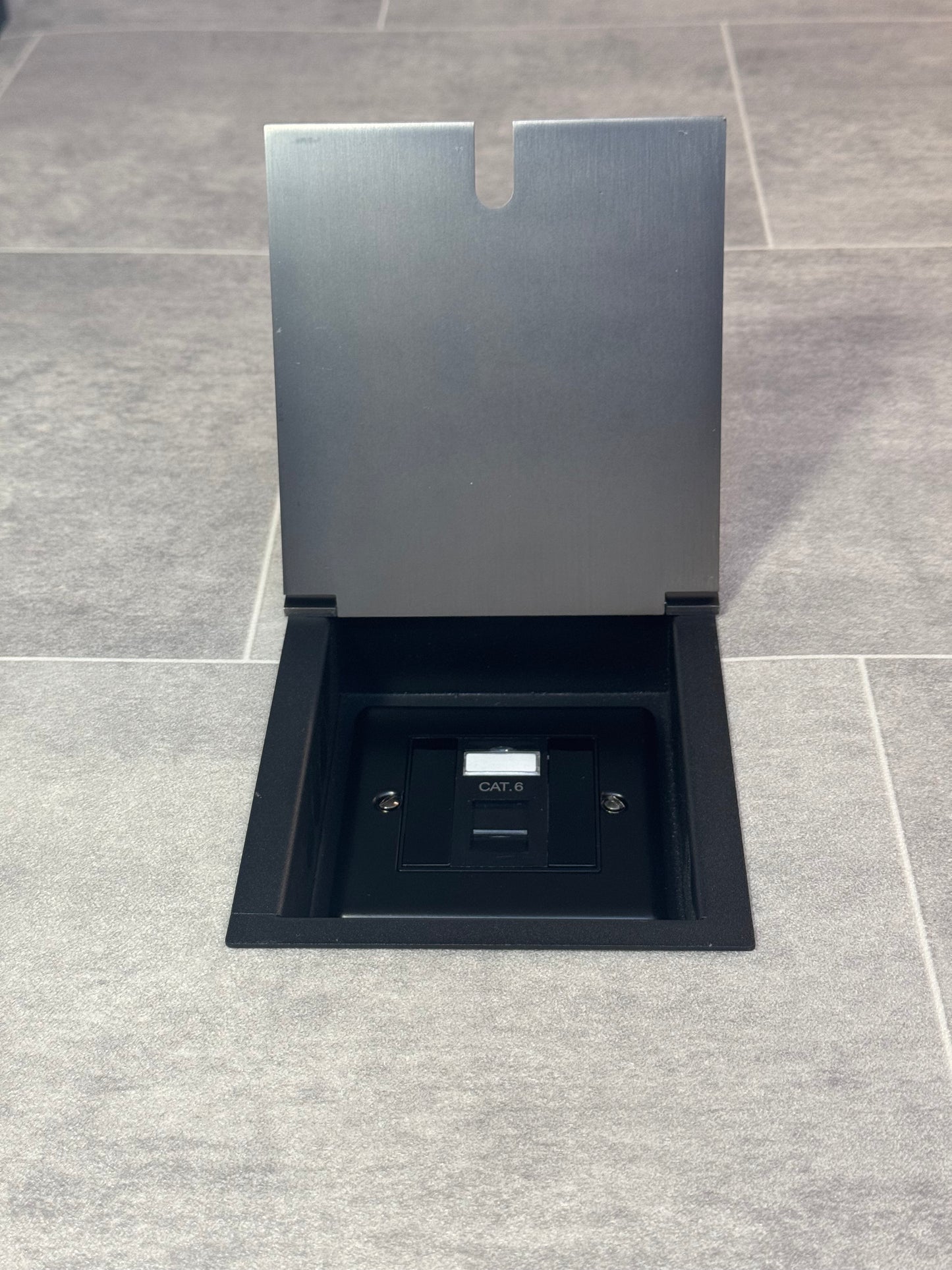Old bronze recessed floor socket with a black base, opened to reveal the internal Cat6 RJ45 socket.