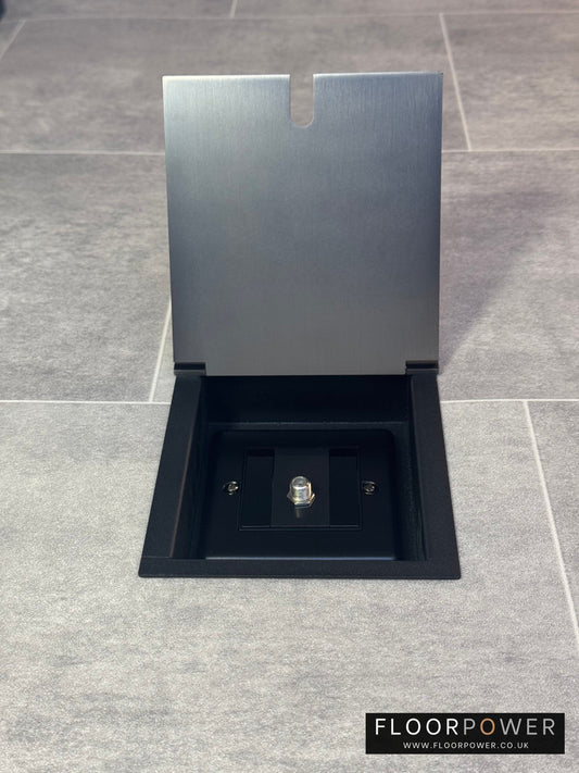 Old bronze recessed floor socket with the cover open showing the single satellite connector inside.