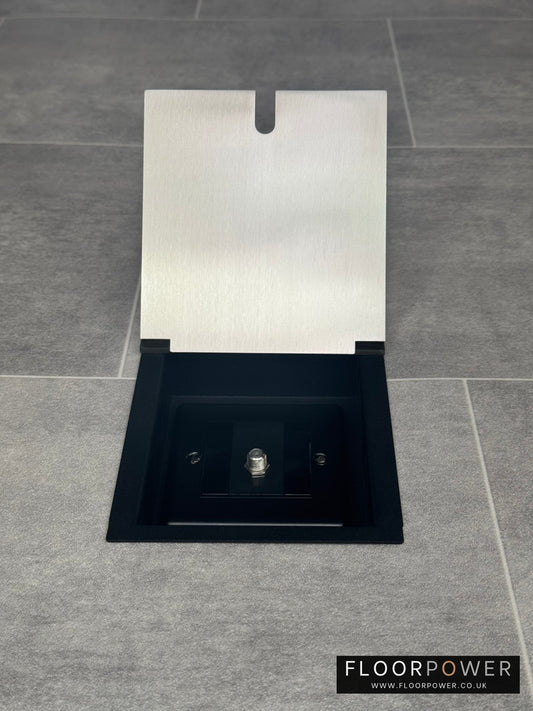 A satin stainless steel recessed floor socket with a single satellite socket, displayed in an open position on a grey tiled floor.