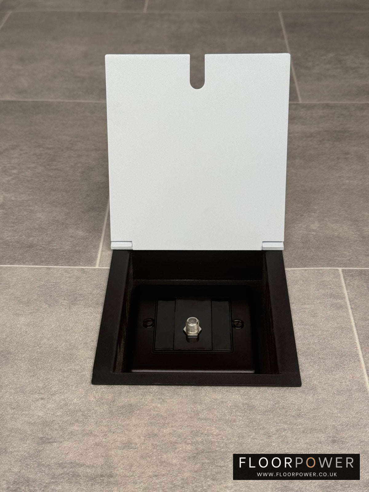 A white recessed floor socket with a single satellite connector.