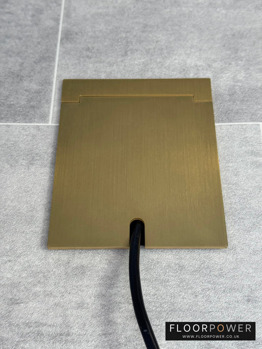 Single Satin Brass Recessed Floor Socket With Lid Closed Flat Showing Just Cable Coming Out If The Socket - Front On View.