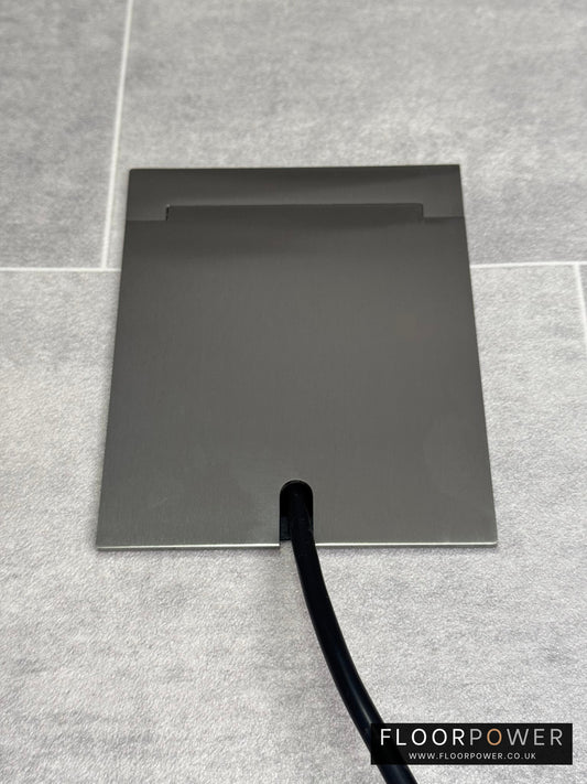 Single Satin Stainless Recessed Floor Socket With Lid Closed Flat Showing Just Cable Coming Out If The Socket - Front On View.