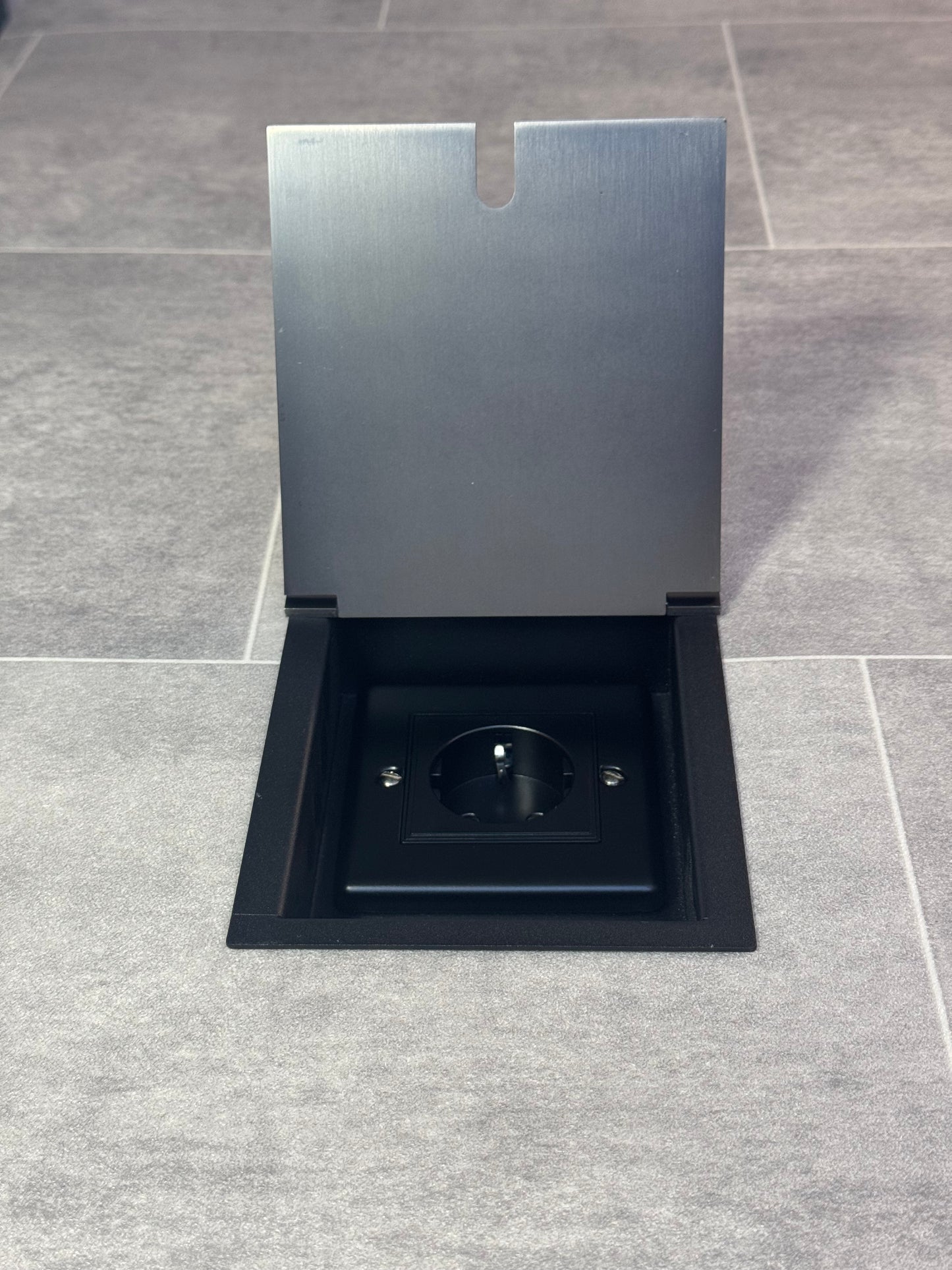 Old bronze recessed floor socket with a single Schuko (European) socket.