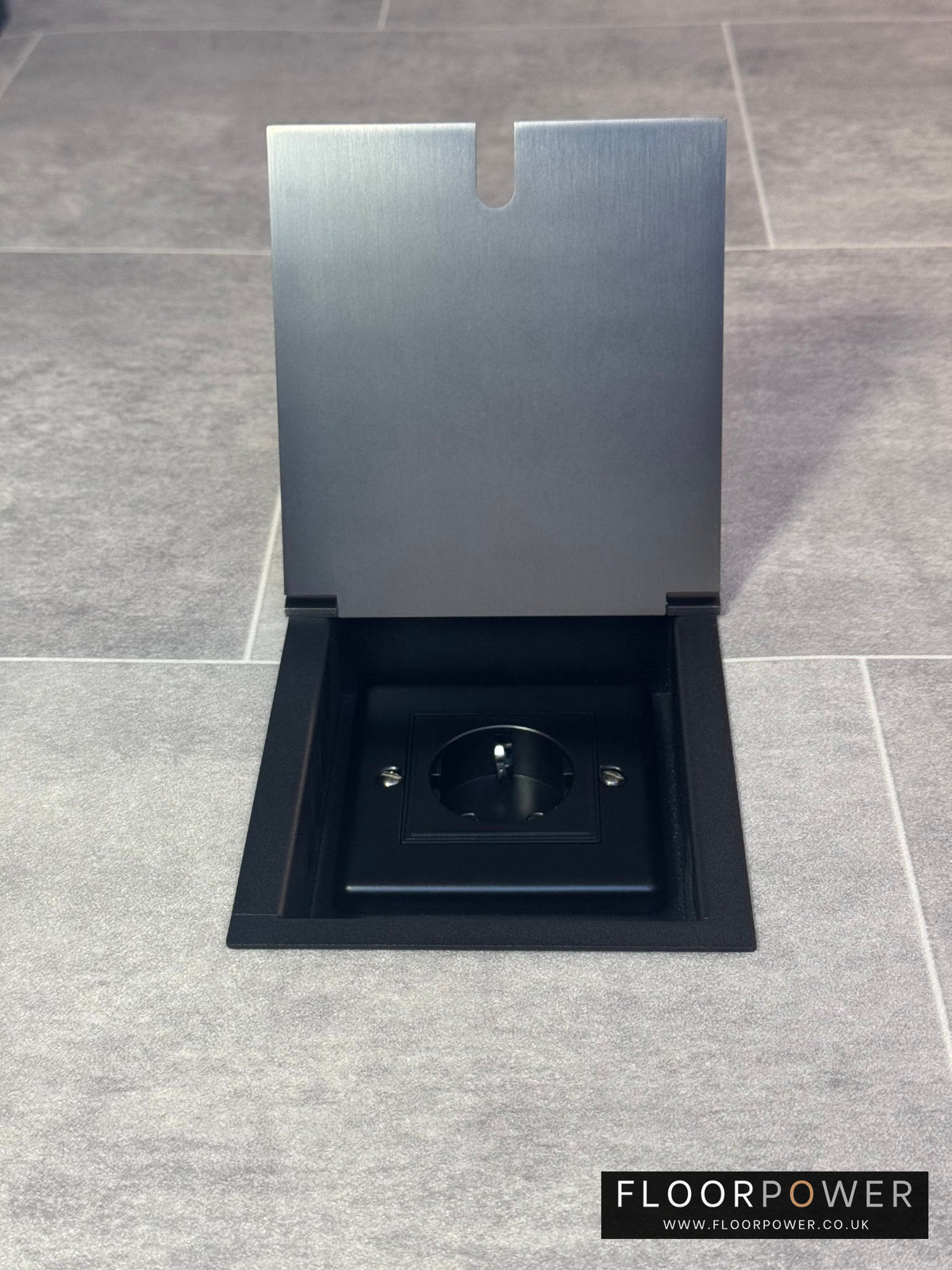 Old bronze recessed floor socket with a single Schuko (European) socket.