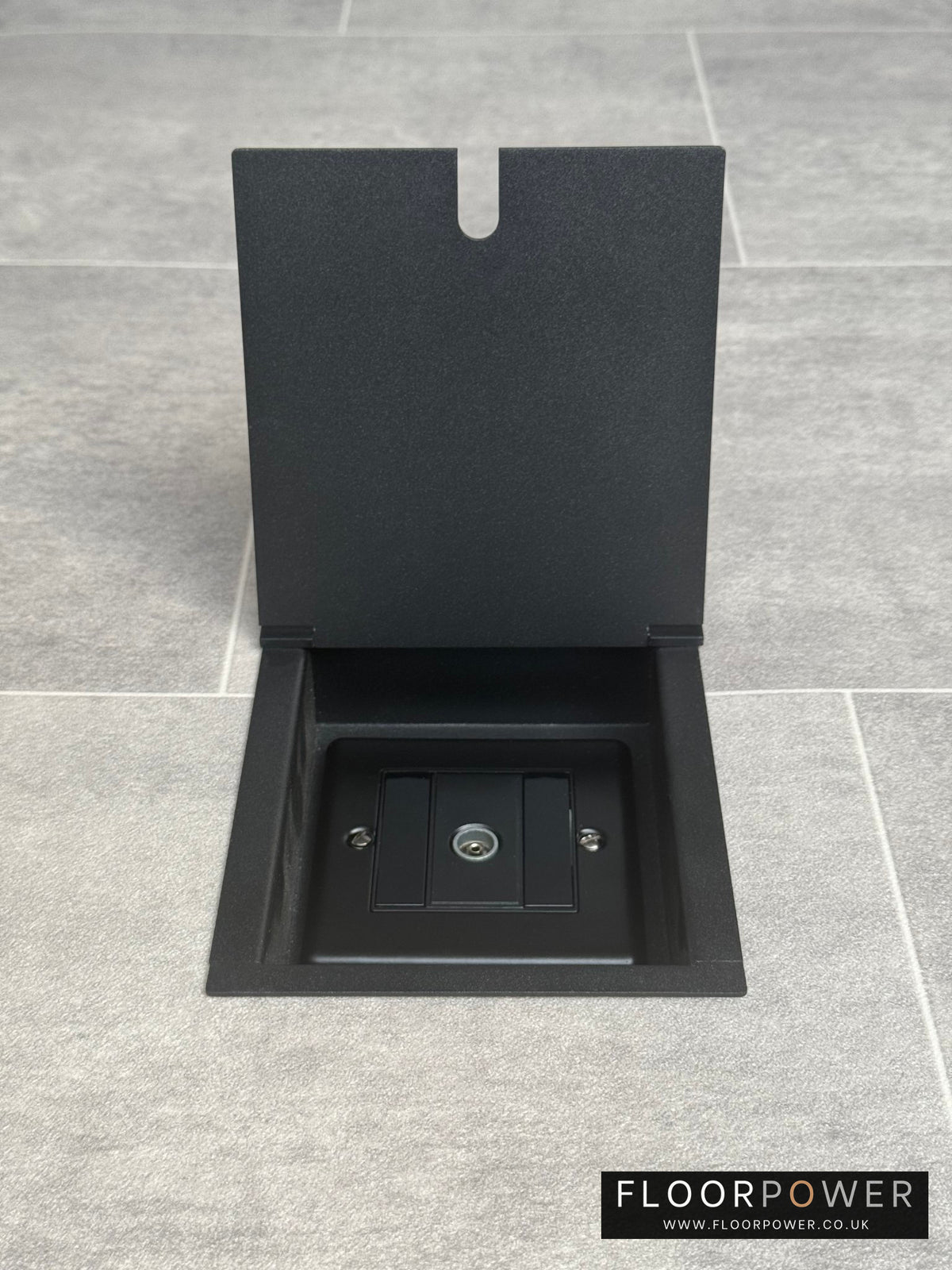 A matt black recessed floor socket designed for integrating a television socket into the floor, shown in an open position.