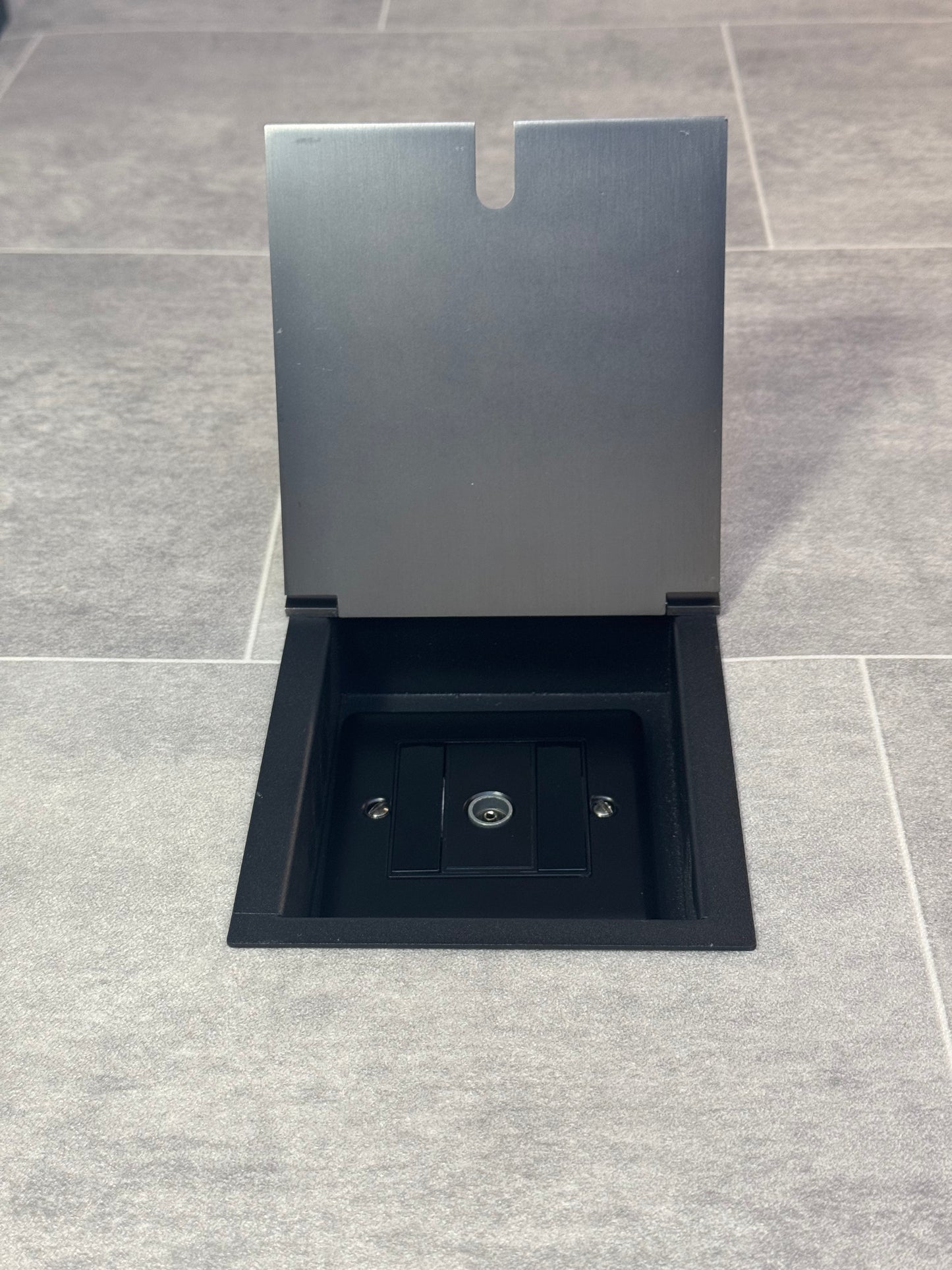 Recessed floor socket in old bronze installed on a tiled floor, featuring a 1 gang TV socket.