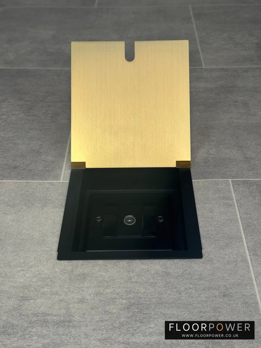A satin brass recessed floor socket with a single 1 gang TV aerial socket, shown open, installed in a floor.