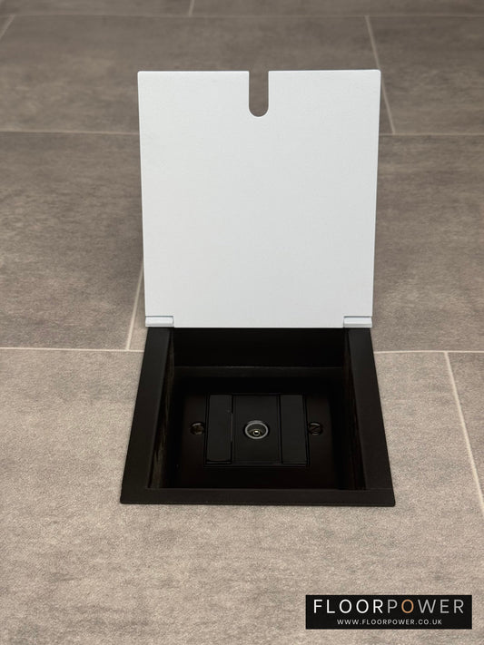 A recessed floor socket with a white lid and a single aerial (TV) socket.