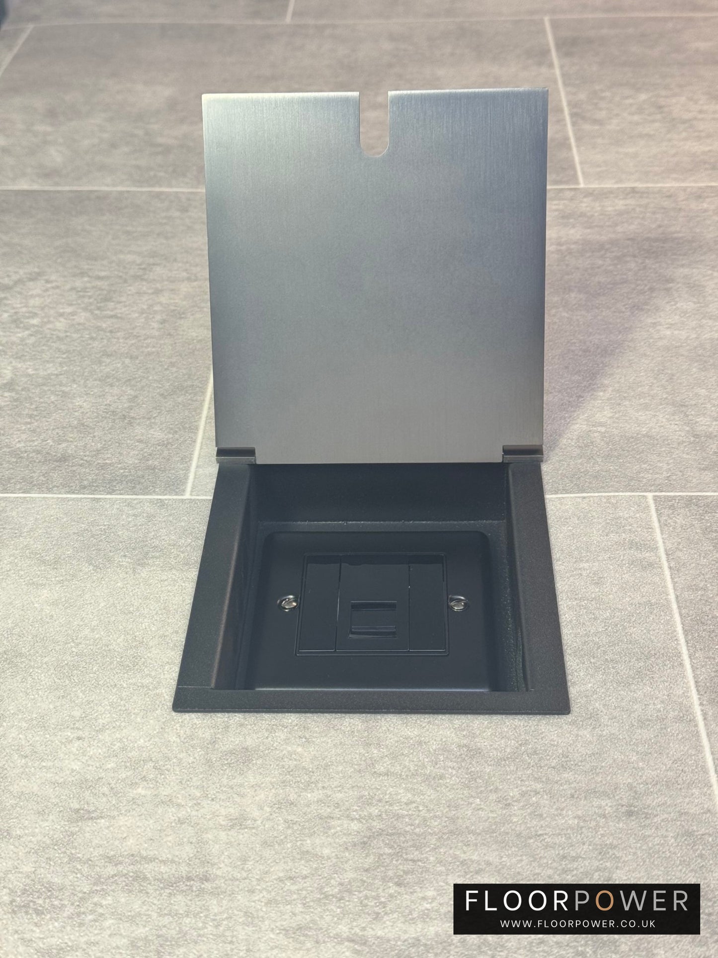 A UK telephone socket in an old bronze recessed floor socket.