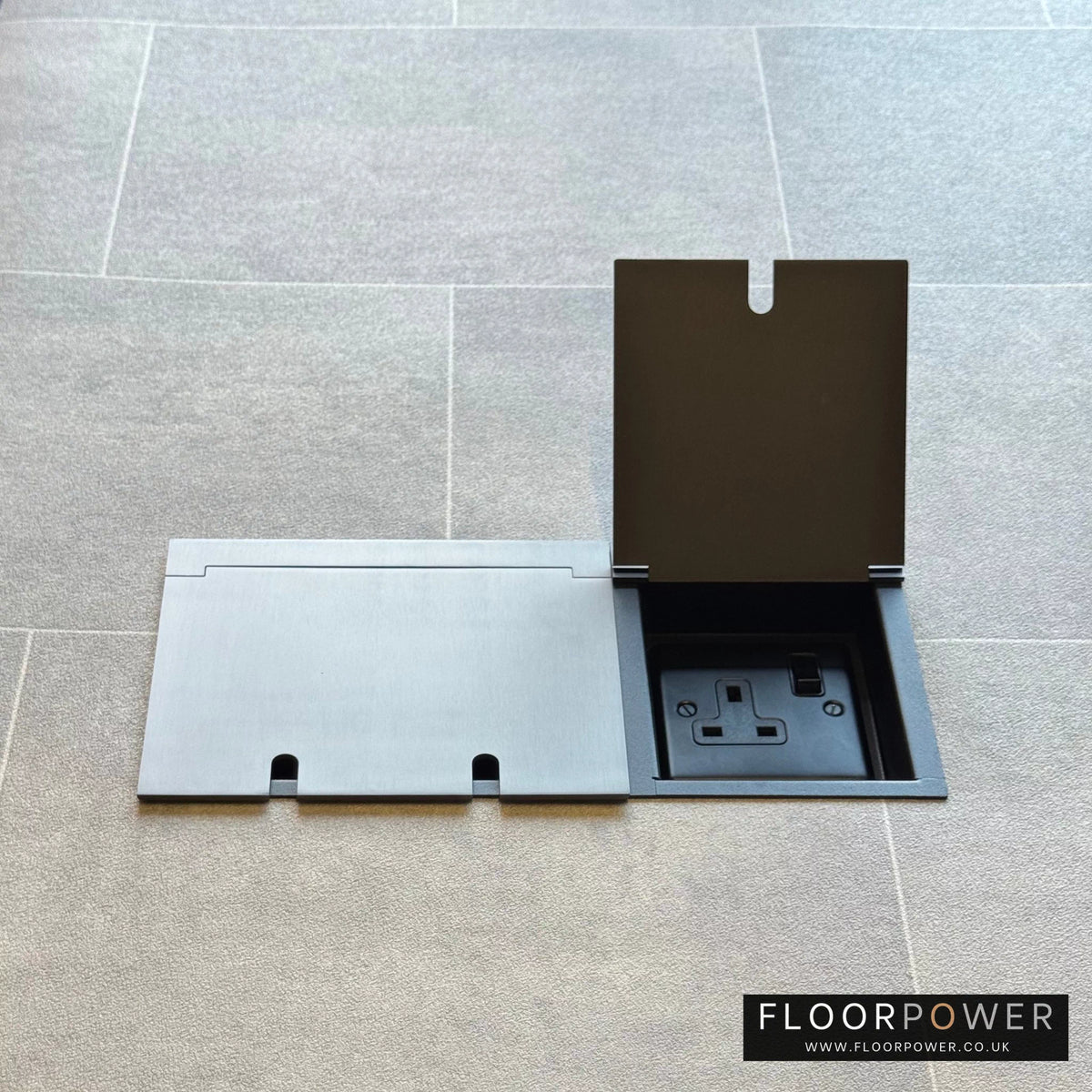 Triple plug floor socket in Old Bronze with single 13A switched plug socket lid open.