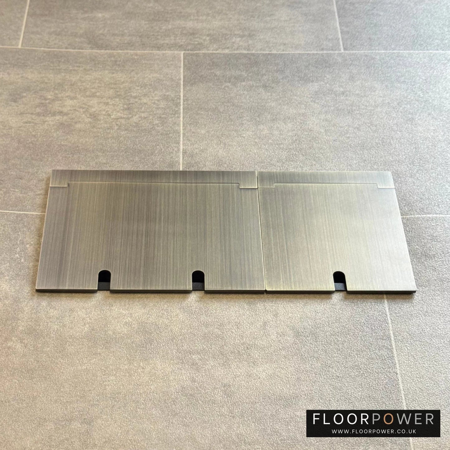 Closed Triple Recessed Floor Socket in Antique Brass on tiled floor.