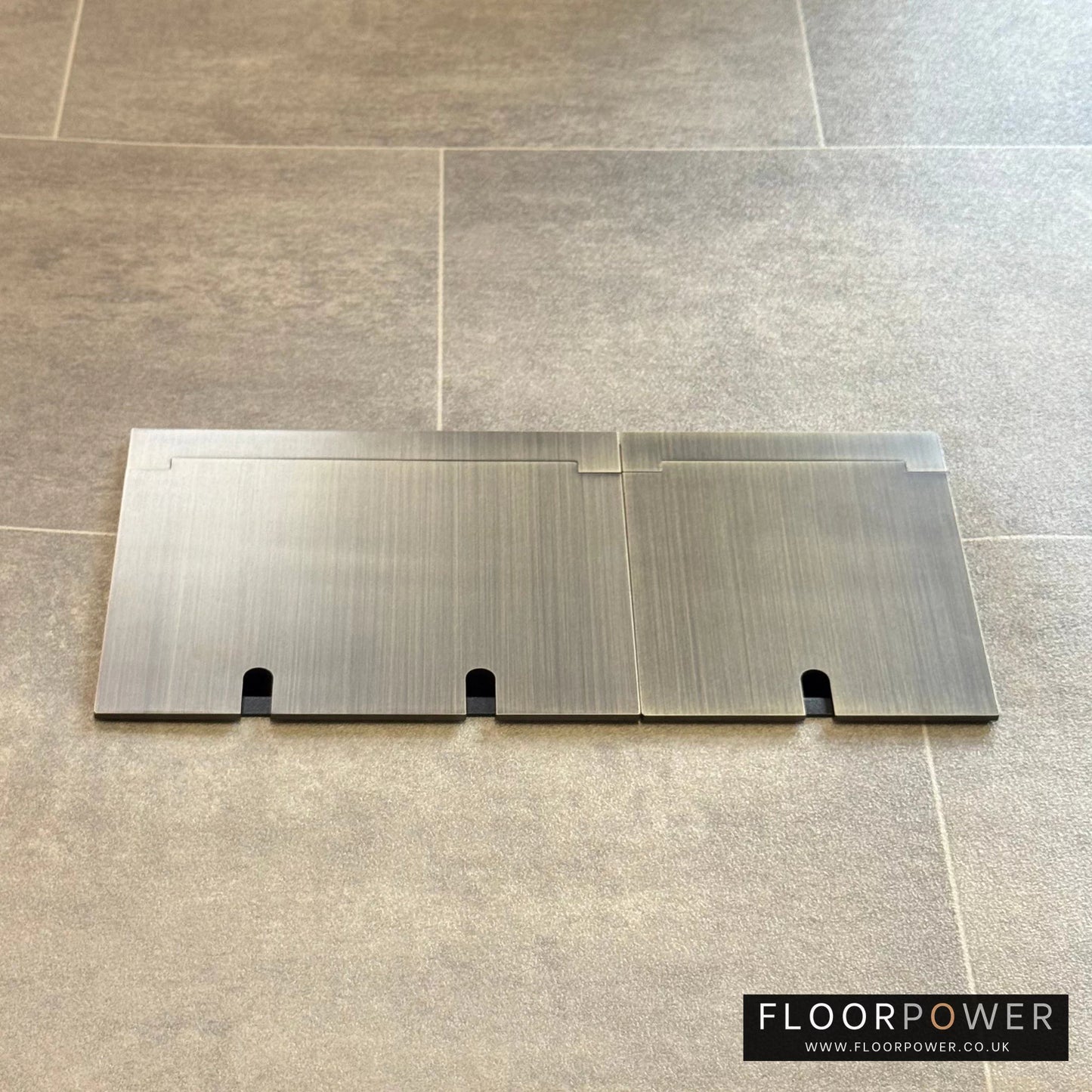 Closed Triple Recessed Floor Socket in Antique Brass on tiled floor.
