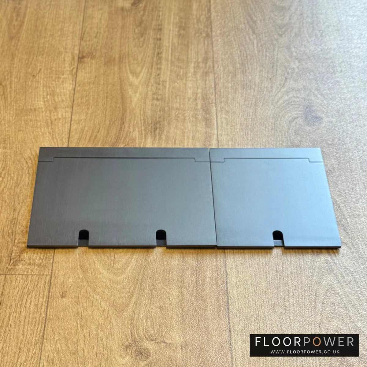 Closed Triple Recessed Floor Socket in Old Bronze on wood floor.