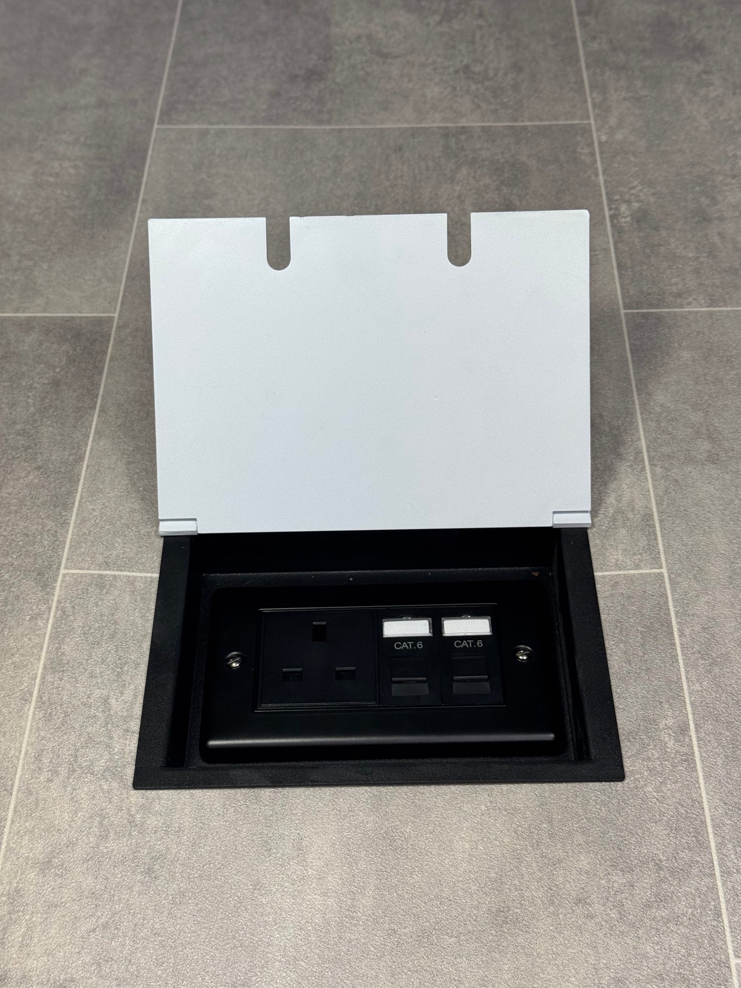 White double recessed floor socket containing one 13amp unswitched socket and two RJ45 sockets in a tiled floor.