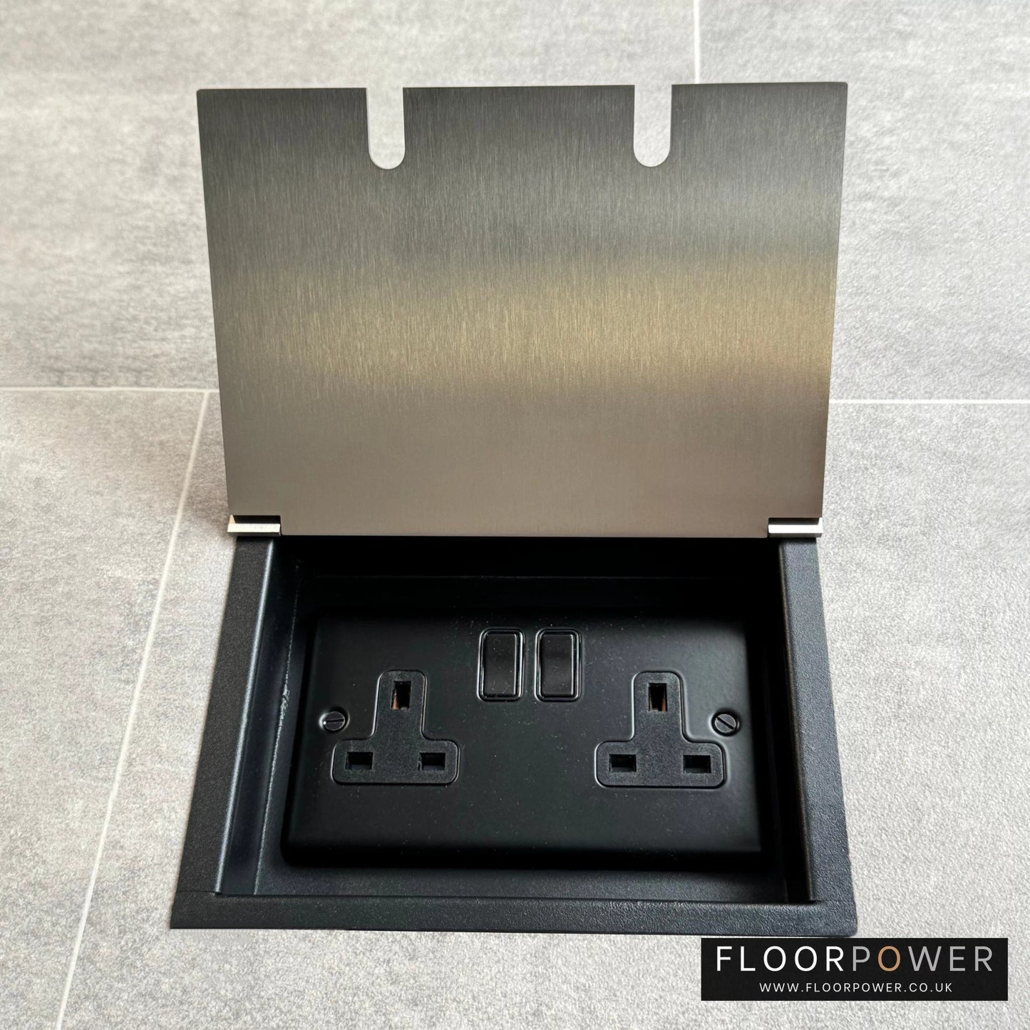 Satin nickel recessed floor socket with a double 13amp switched plug socket, in a tiled floor.