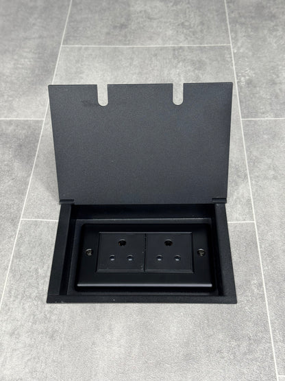 Double 5 amp recessed floor socket for lighting with matt black lid set into the floor.