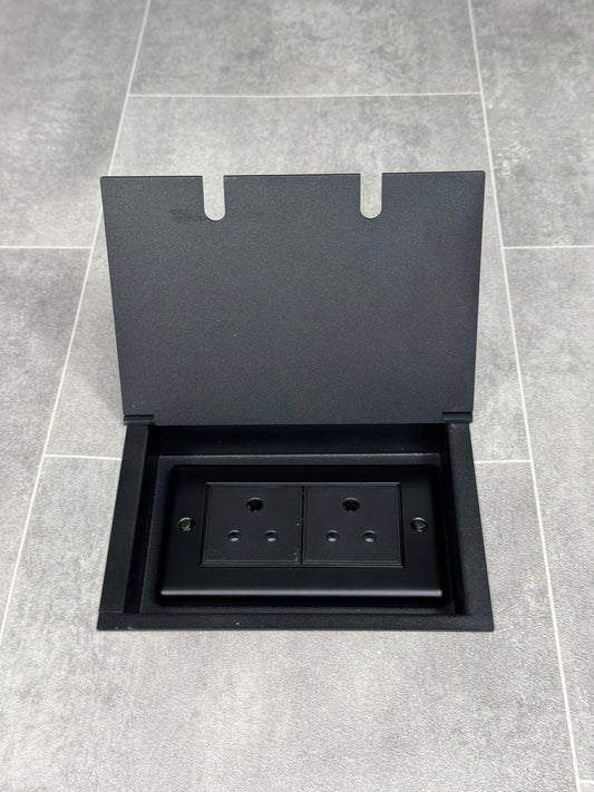 Double 5 amp recessed floor socket for lighting with matt black lid set into the floor.