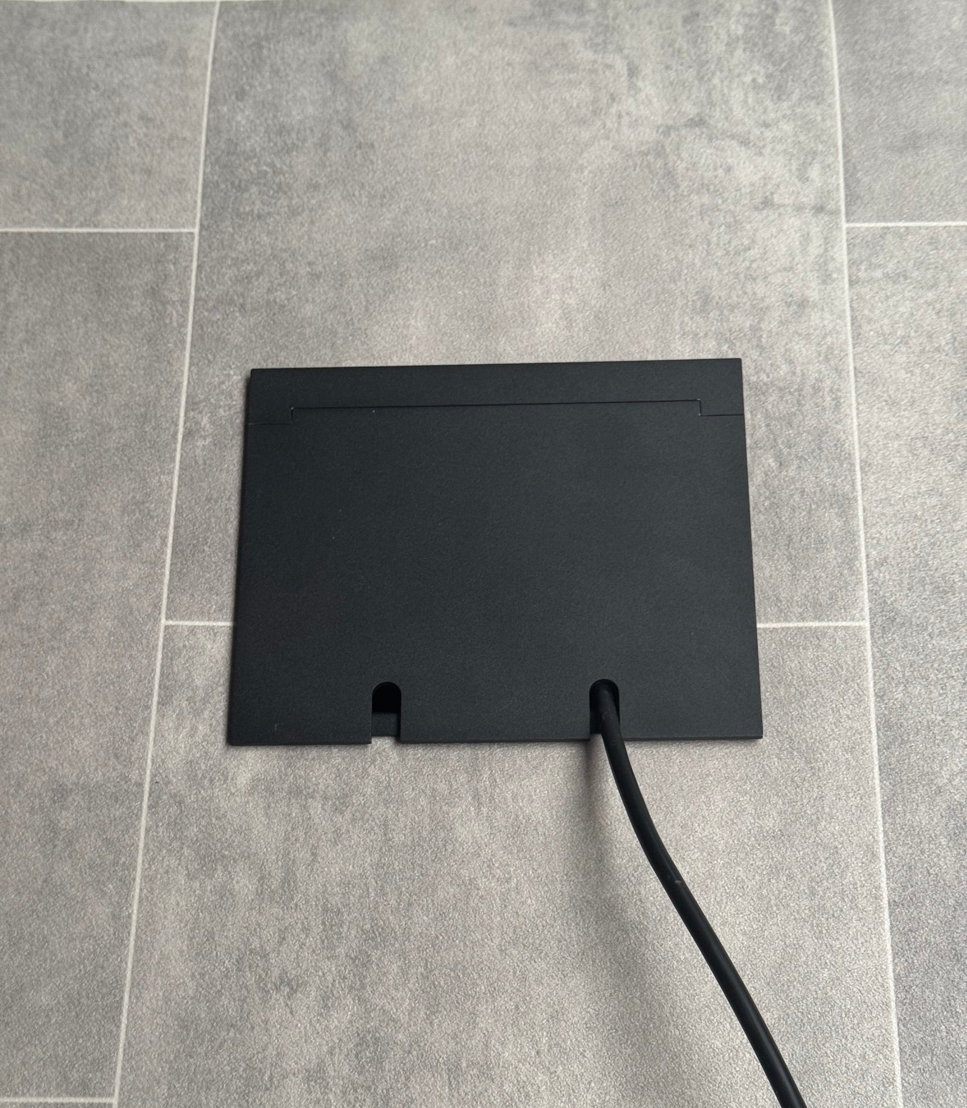 Double Matt Black Recessed Floor Socket With Lid Closed Flat Showing Just Cable Coming Out If The Socket - Front On View